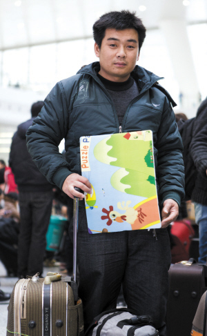 唐师傅拿着志愿者送的坐垫准备回老家。