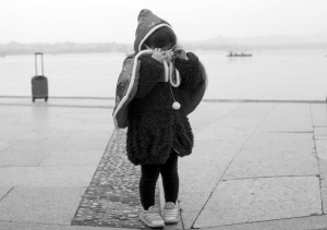 昨天，西湖边，一个小女孩穿上披风，戴上口罩后还是说很冷。