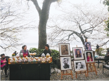 昨天早上，有市民途经平湖秋月“樱花王”下时，拍到的茶摊和画摊。 连国庆 摄