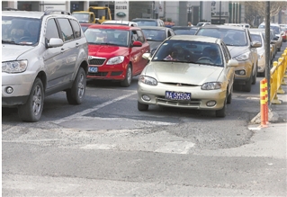 建国路凤起路口，路面补丁处处，车子开过颠簸不已。 