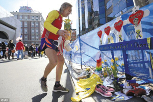 一位参加2014年波士顿马拉松赛的选手，给2013年波士顿马拉松爆炸案遇难者献花。 