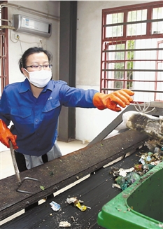 记者体验垃圾分类，刚从厨余垃圾中拣出一只鞋。 魏志阳 摄 