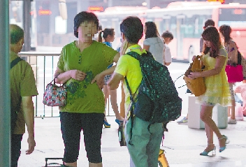 昨天，在杭州火车东站西广场，几名“黄牛”正在招揽旅客。 陈嘉澍 摄    