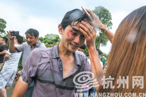 下沙七格江边，一位观潮者被潮水打翻在地后受伤流血。 