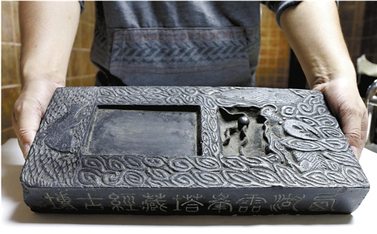 雷峰塔藏经砖的正面被制成了砚台，侧面仍保留着藏经孔。