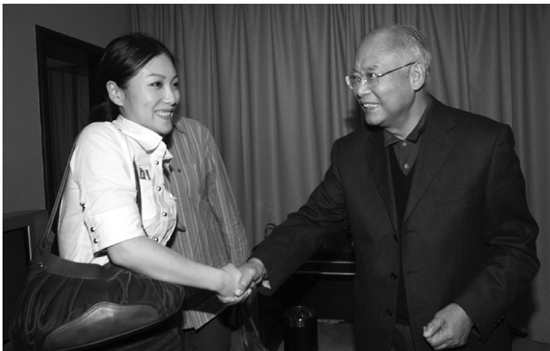 2007年来杭州时，何振梁与本报记者王晓露（左）亲切握手。