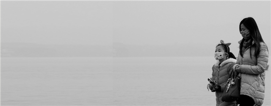1月17日午后的西湖边，灰霾依旧不散，不少游客戴上口罩。
