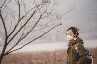 雾霾下的西湖景区，游客戴着口罩出行。