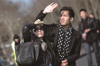 昨天下午,西湖边,一些游客抬头找寻空中的风筝,用手遮挡刺眼的阳光.