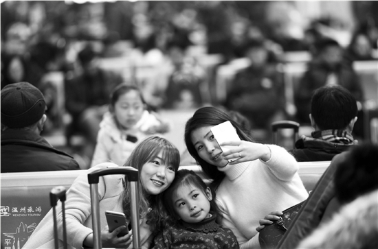 在杭州火车东站候车室，来自合肥的小姐妹与女儿一起自拍留念，回家喜悦写满了脸庞。