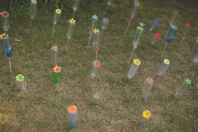 太子湾公园，美院学生在收集的塑料瓶上画上花朵，点缀草坪。摄影 记者 陈荣辉