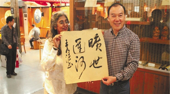 王水法与胡贾女士，正在展示“旷世运河”四个大字。