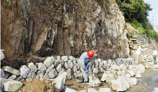 7月5日，在舟山普陀区樟州渔业村，施工人员正在山边用石片砌墙，以防边坡被雨水冲刷倒塌。 胡社友 摄