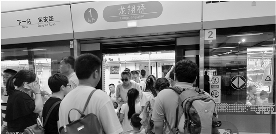 龙翔桥站上下客，乘客们几乎是一拥而上。本报记者 李震宇 摄