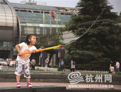昨天下午，运河边，一个小女孩在玩水枪。 记者 夏阳 摄