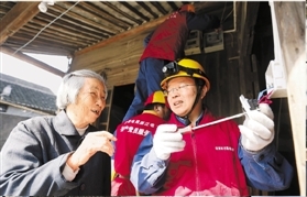 钱海军（右）在帮老人检查电闸开关。