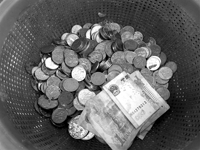 屏风街菜场一位大姐的塑料筐里，大部分是一元硬币，只有几张皱巴巴的一元纸币。 