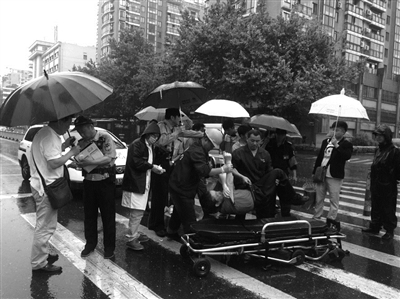 5月2日，倒在斑马线上的华师傅被抬上120救护车 读者 朱先生 摄