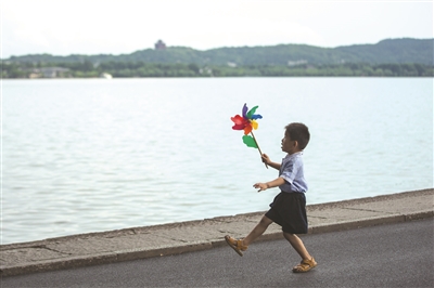 西湖边，一个小男孩在玩风车。 记者 陈中秋 摄