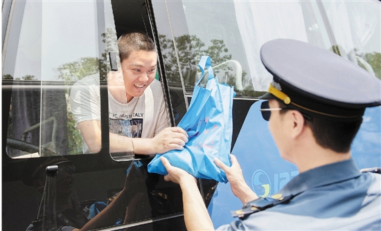 景宁畲族自治县道路运管工作人员向司机发防暑用品。 李肃人 沈奇云 摄
