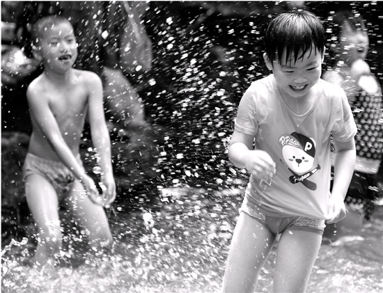  昨日，游客在杭州九溪景区嬉水。最高兴的是孩子们，他们痛痛快快地在溪涧里玩水枪，打水仗，在遮天蔽日的树阴下，享受比市区气温低3～5℃的自然清凉。 本报记者 董旭明 摄