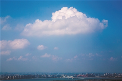 一朵巨大的白云飘过九堡大桥上空。