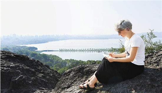 早晨六点，坐在宝石山顶的岩石上，Machi眺望着被秀美山水环抱的城市，手中的画笔唰唰唰地动了起来。约20分钟后，一幅简约别致的“杭州印象”插画诞生了。