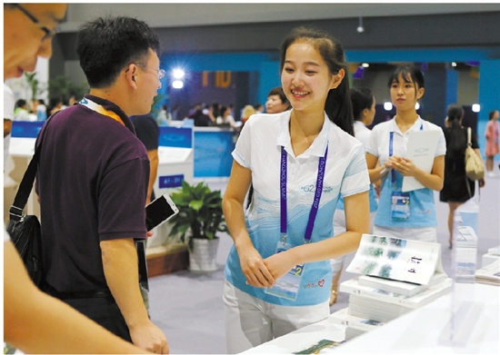 在G20杭州峰会新闻中心，满脸笑容的“小青荷”正在为中外记者服务。 