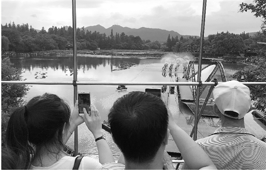游客们在跨虹桥上观看演员排练。
