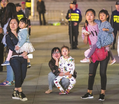 昨晚，秋夜微凉，3个妈妈把孩子抱在怀里，一起观看武林广场音乐喷泉。 