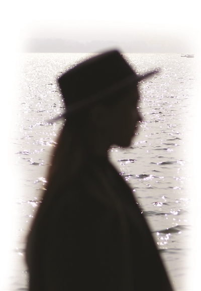 昨天天气很好，一位女生走在西湖边，身体轮廓闪烁着粼粼的波光。
