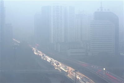 昨天早上7点，中河高架上的车辆在雨雾朦胧中行驶。 