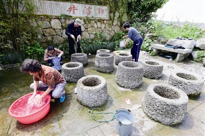 郭婆井边，居民聚在一起干活、聊天。