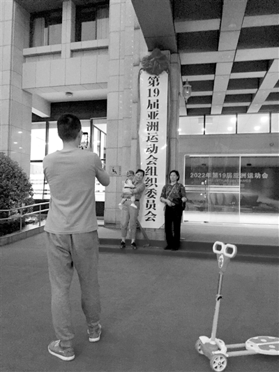 昨天傍晚，市民们在新挂牌的杭州亚组委办公大楼前拍照留念。