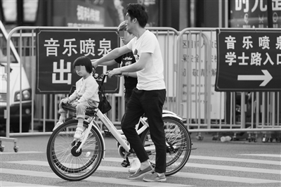 4月19日，东坡路，一个小孩坐在共享单车车篮上。 记者 严嘉俊 摄