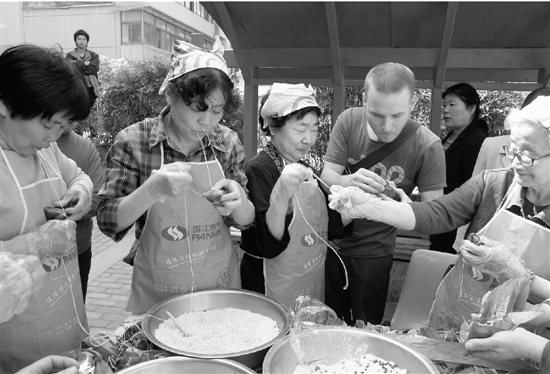 孙新宝教居民和外籍友人包粽子，体味传统端午情。