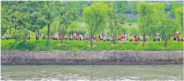 来自全国各地的健身爱好者齐聚大运河畔,沿着风景秀丽的大运河郊野绿道徒步。记者 李忠 摄