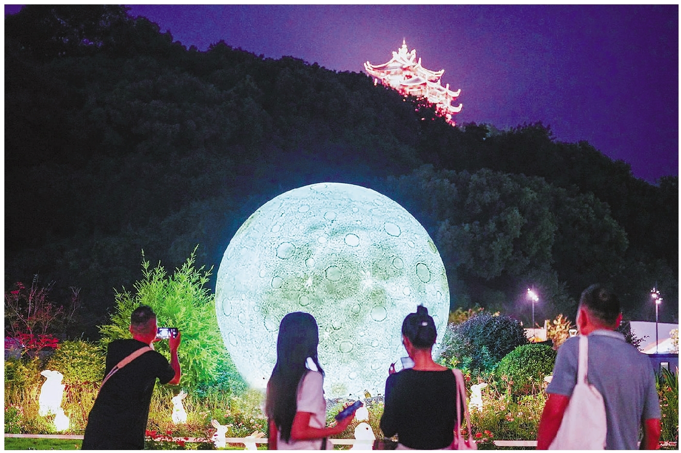 中秋佳节,一轮直径3米的“超级月亮”在吴山广场的花海里“升起”,与灯火辉煌的城隍阁相呼应。记者 李忠 摄
