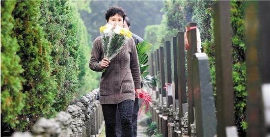 4月3日上午，杭城下起春雨，扫墓的群众在杭州南山陵园向故人献上鲜花。 