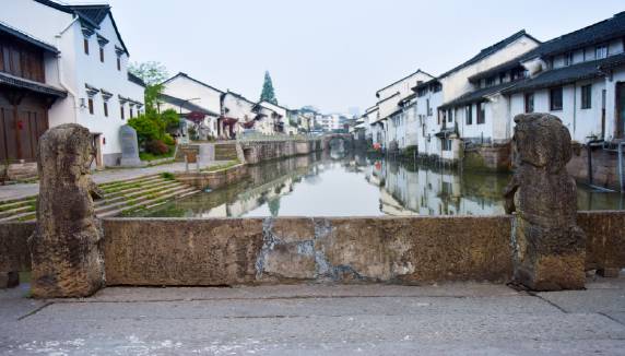 在官河尽头，一座不石桥上立着两只石狮，一只张着嘴巴，一只闭着